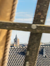Kerktoren Veen gezien door het hekwerk van de molen van VVV Biesboschlinie